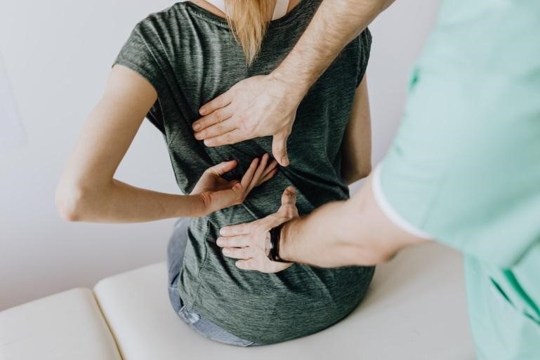 A doctor examining a woman’s back