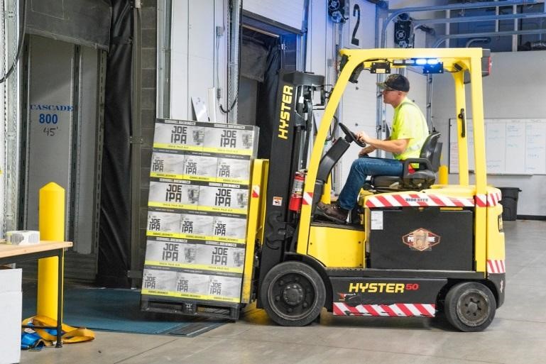 A man operating a yellow forklift