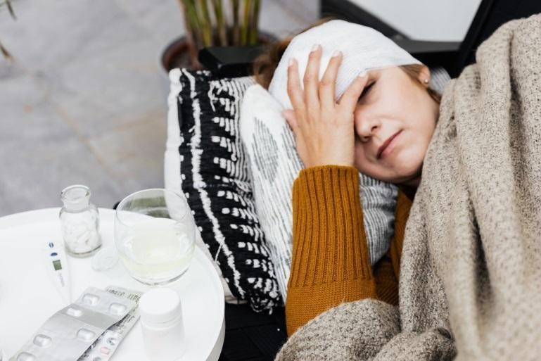 A woman with a head & eye bandage lying on a couch