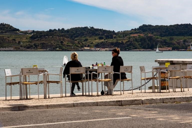 Two women sitting on chairs overlooking the ocean