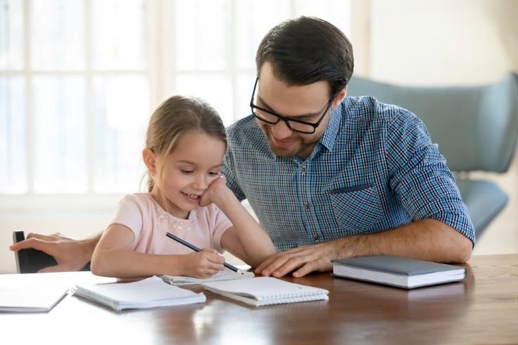 A father helping his daughter read